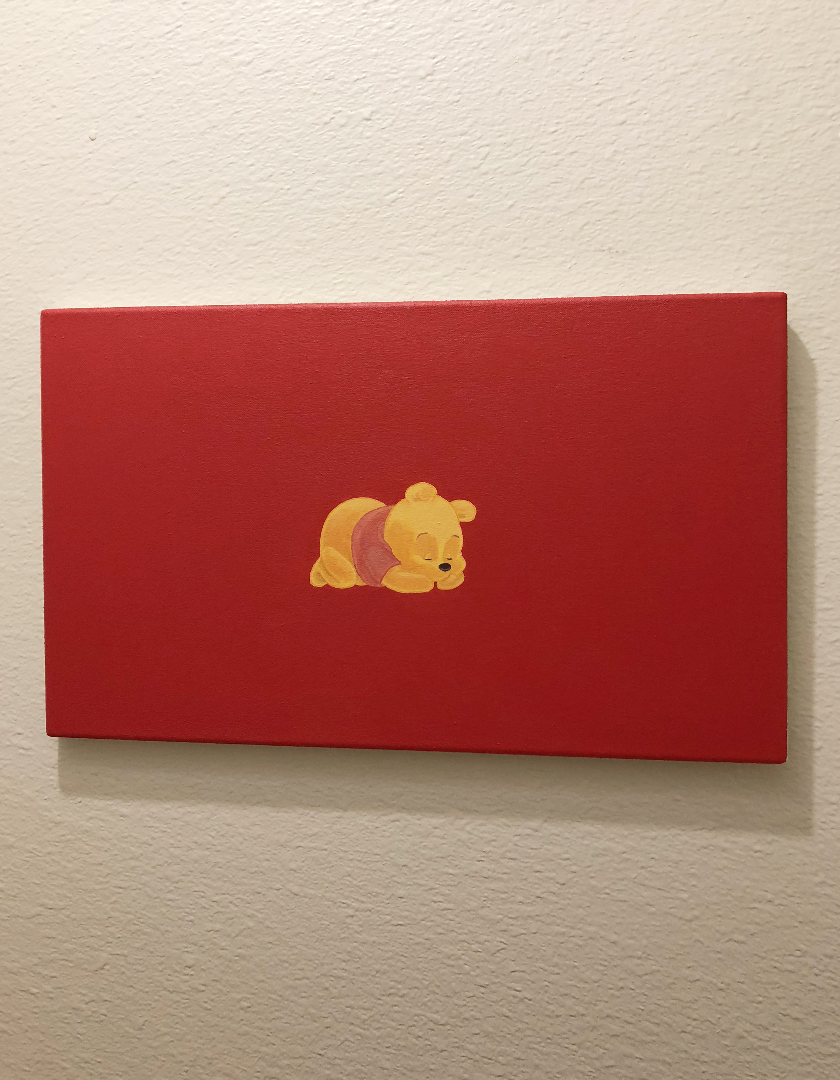 Painting of winnie the pooh lying asleep on a red background hung on a white wall
